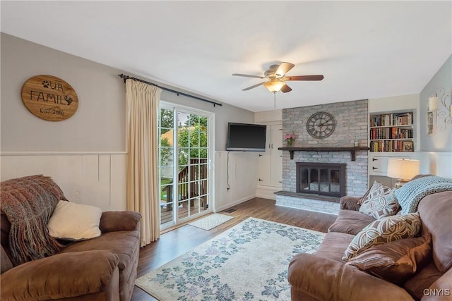 22 Tree Line Dr, Clay, NY 13090 - living area featuring a ceiling fan, wood finished floors, a brick fireplace, and a wainscoted wall