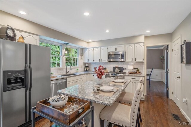 9607 Dunderry, Lysander, NY 13027 - kitchen featuring stainless steel appliances, white cabinets, light stone counters, dark wood-style flooring, and backsplash