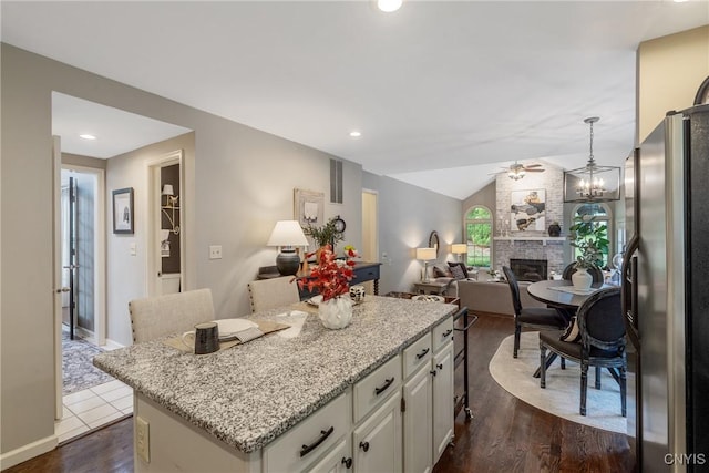 9607 Dunderry, Lysander, NY 13027 - kitchen with freestanding refrigerator, a center island, dark wood finished floors, vaulted ceiling, and white cabinets