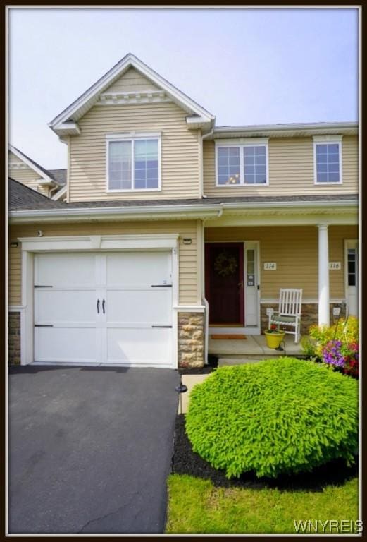 114 Slate Bottom Dr, Lancaster, NY 14043 - view of front of property featuring stone siding, covered porch, and asphalt driveway