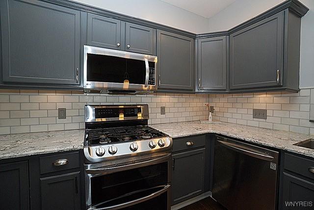 114 Slate Bottom Dr, Lancaster, NY 14043 - kitchen with appliances with stainless steel finishes, light stone counters, and tasteful backsplash