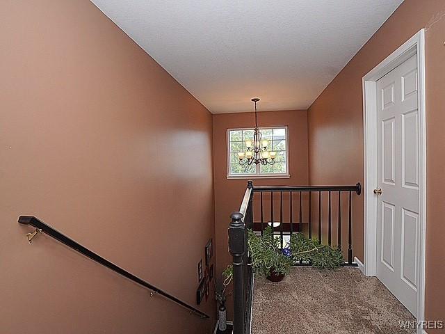 114 Slate Bottom Dr, Lancaster, NY 14043 - stairs with a chandelier and carpet