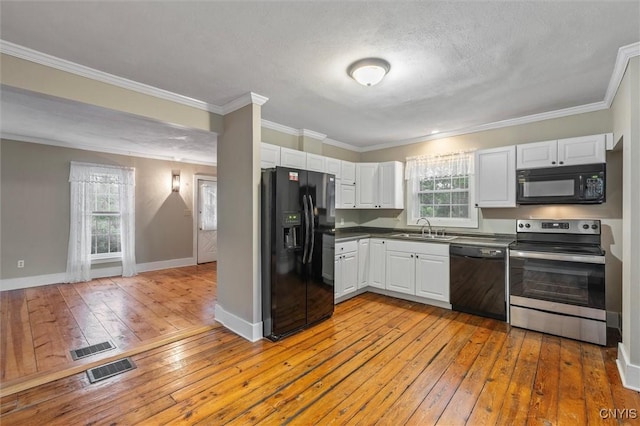 17 Burr St, Cazenovia, NY 13035 - kitchen featuring black appliances, light wood-style flooring, white cabinetry, dark countertops, and crown molding