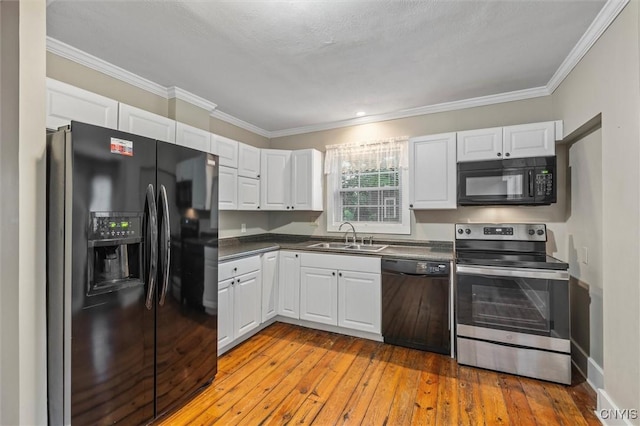 17 Burr St, Cazenovia, NY 13035 - kitchen featuring black appliances, white cabinets, dark countertops, crown molding, and light wood-style floors