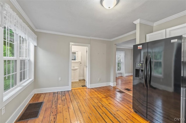 17 Burr St, Cazenovia, NY 13035 - kitchen featuring black fridge with ice dispenser, light wood-style flooring, crown molding, and white cabinetry