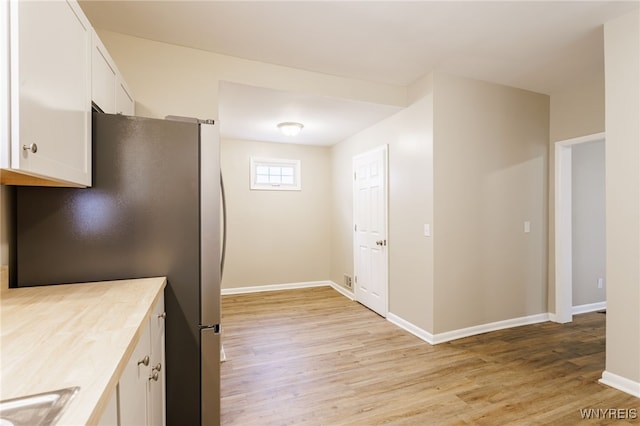 708 Garson Ave, Rochester, NY 14609 - kitchen with freestanding refrigerator, light wood finished floors, white cabinetry, and light countertops