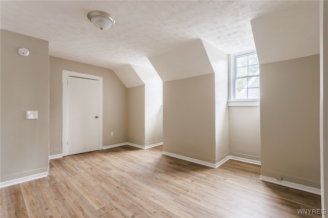 708 Garson Ave, Rochester, NY 14609 - additional living space with a textured ceiling, light wood-type flooring, and lofted ceiling