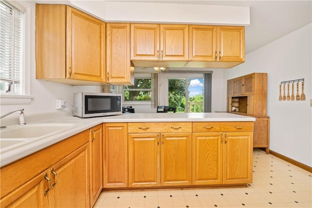 1732 Buffalo Rd, Gates, NY 14624 - kitchen featuring white microwave, light countertops, a peninsula, and light flooring