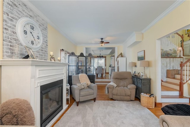 157 Dennis Ave, Hornell, NY 14843 - living area featuring a glass covered fireplace, stairs, a ceiling fan, wood finished floors, and ornamental molding