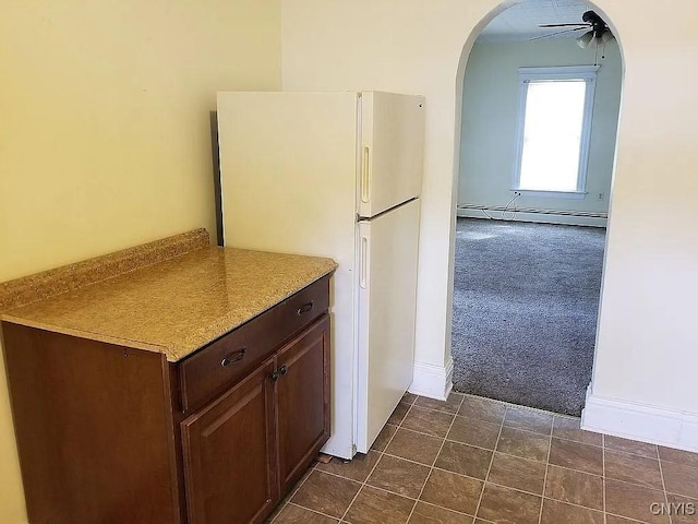 116 E Heman St, Dewitt, NY 13057 - kitchen featuring dark carpet, baseboard heating, freestanding refrigerator, arched walkways, and a ceiling fan