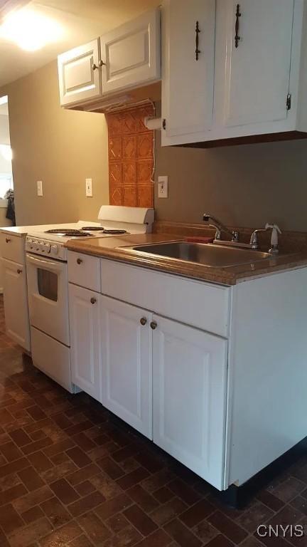116 E Heman St, Dewitt, NY 13057 - kitchen with white range, brick patterned floors, and white cabinets