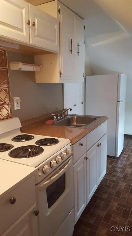 116 E Heman St, Dewitt, NY 13057 - kitchen featuring white appliances, brick flooring, white cabinetry, and light countertops