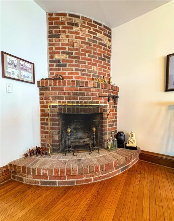 80 E Main St, Leroy, NY 14482 - detailed view of a brick fireplace and wood finished floors