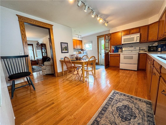 80 E Main St, Leroy, NY 14482 - kitchen featuring white appliances, brown cabinetry, track lighting, and light wood-style flooring