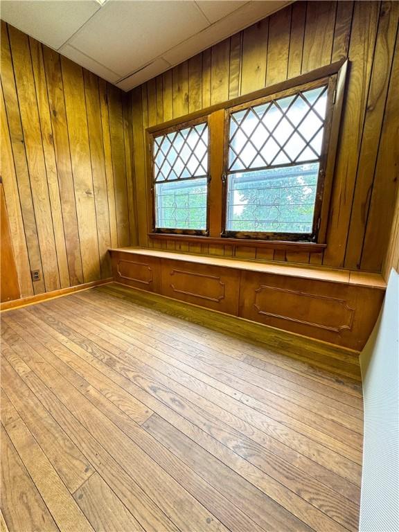 80 E Main St, Leroy, NY 14482 - unfurnished room featuring wood-type flooring, healthy amount of natural light, and wooden walls