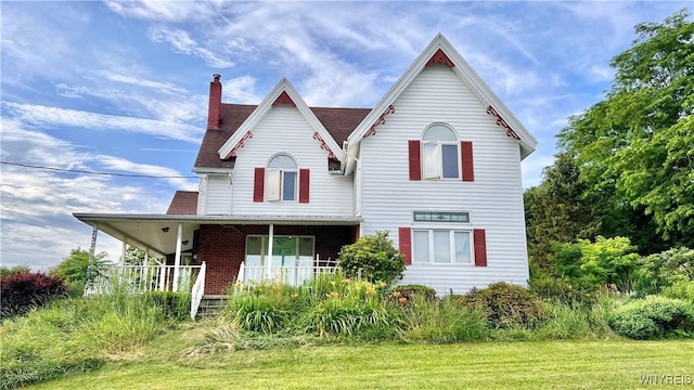 7320 E Flats Rd, East Otto, NY 14729 - victorian house featuring a chimney, a porch, and a front lawn
