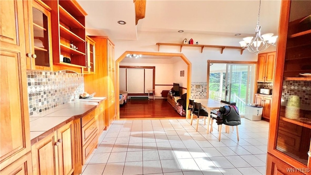 7320 E Flats Rd, East Otto, NY 14729 - kitchen with open shelves, tile countertops, a chandelier, recessed lighting, and backsplash