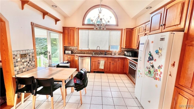 7320 E Flats Rd, East Otto, NY 14729 - kitchen with appliances with stainless steel finishes, a chandelier, light tile patterned floors, tasteful backsplash, and vaulted ceiling