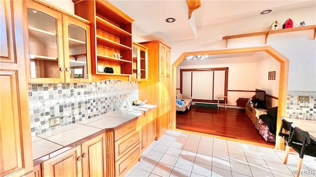 7320 E Flats Rd, East Otto, NY 14729 - kitchen with tile countertops, open shelves, light tile patterned flooring, tasteful backsplash, and glass insert cabinets
