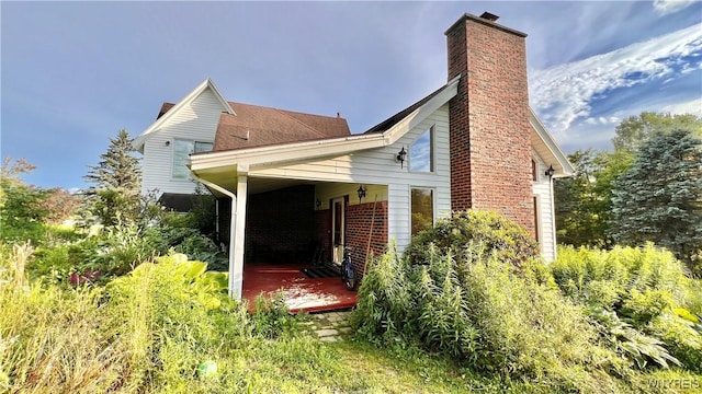 7320 E Flats Rd, East Otto, NY 14729 - view of property exterior featuring a chimney and a patio area