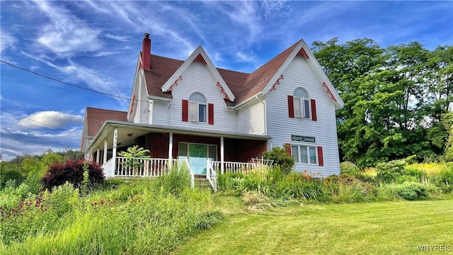 7320 E Flats Rd, East Otto, NY 14729 - victorian-style house featuring a chimney, covered porch, and a front yard