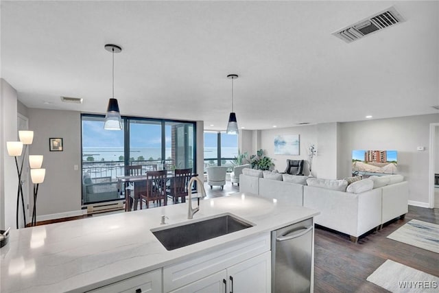 803 Admirals Walk Unit 803, Buffalo, NY 14202 - kitchen featuring dark wood-style flooring, white cabinets, light stone countertops, pendant lighting, and a wall of windows