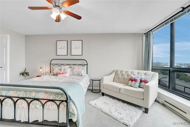 803 Admirals Walk Unit 803, Buffalo, NY 14202 - carpeted bedroom with a baseboard heating unit, multiple windows, a ceiling fan, and a wall of windows