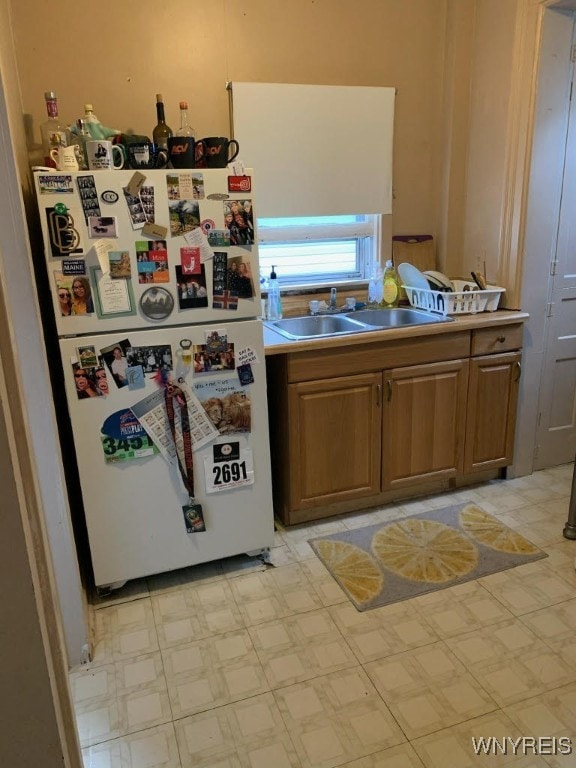 184 Goundry St, North Tonawanda, NY 14120 - kitchen featuring freestanding refrigerator, light countertops, light flooring, and brown cabinets