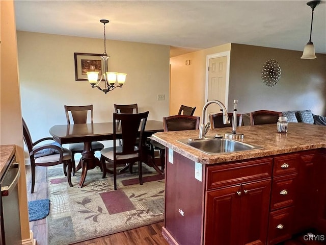 206 Wembridge Dr, Dewitt, NY 13057 - kitchen featuring dark brown cabinets, dark wood-style floors, pendant lighting, a chandelier, and a kitchen island with sink