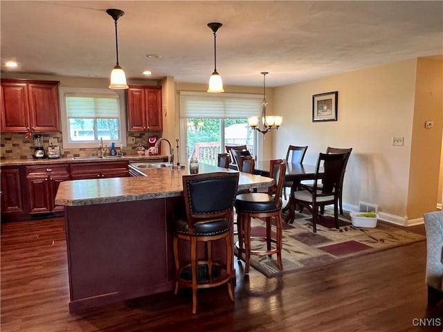 206 Wembridge Dr, Dewitt, NY 13057 - kitchen with a breakfast bar, a center island with sink, backsplash, dark wood-type flooring, and recessed lighting