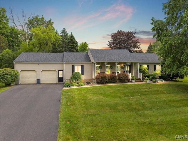 124 Morgan Ln, Oneida, NY 13421 - ranch-style home featuring an attached garage, a front yard, asphalt driveway, and a porch