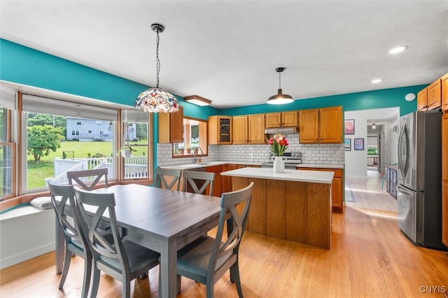 124 Morgan Ln, Oneida, NY 13421 - kitchen featuring stainless steel appliances, light countertops, a center island, under cabinet range hood, and brown cabinets