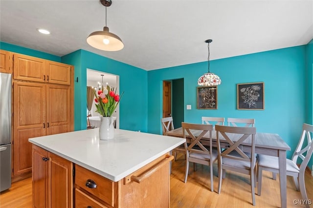 124 Morgan Ln, Oneida, NY 13421 - kitchen featuring light wood-type flooring, stainless steel refrigerator, a kitchen island, light countertops, and hanging light fixtures