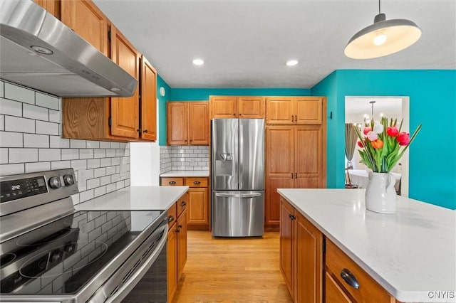 124 Morgan Ln, Oneida, NY 13421 - kitchen with stainless steel appliances, extractor fan, light wood finished floors, light countertops, and backsplash