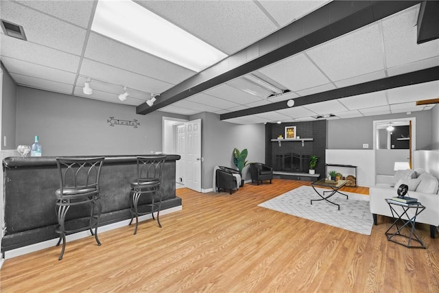 911 Copperkettle Rd, Webster, NY 14580 - living room featuring wood finished floors, a paneled ceiling, a bar, and a fireplace