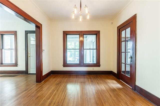 1085 Garson Ave, Rochester, NY 14609 - spare room with wood finished floors, a chandelier, and ornamental molding