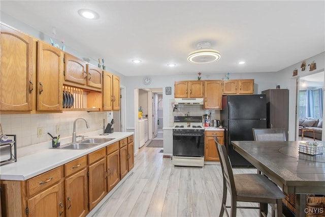 217 Melrose Ave, Camillus, NY 13219 - kitchen with white range with gas stovetop, under cabinet range hood, freestanding refrigerator, decorative backsplash, and light countertops
