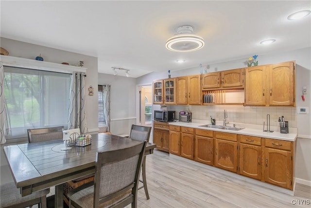 217 Melrose Ave, Camillus, NY 13219 - kitchen with light countertops, decorative backsplash, light wood-style flooring, brown cabinetry, and stainless steel microwave
