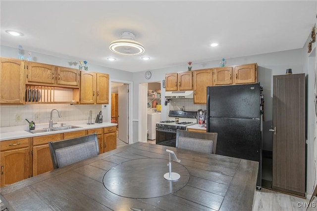 217 Melrose Ave, Camillus, NY 13219 - kitchen featuring white range with gas stovetop, freestanding refrigerator, decorative backsplash, washer / clothes dryer, and under cabinet range hood