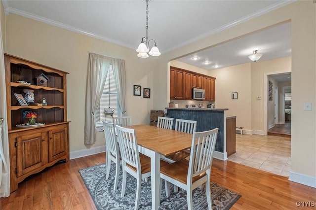 37 Augustus St, Auburn, NY 13021 - dining room featuring ornamental molding, a chandelier, and light wood-style flooring