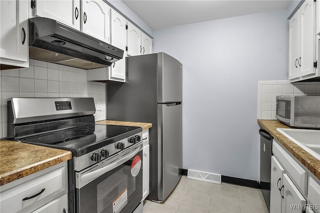145 Charter Oaks Dr Unit 2, Amherst, NY 14228 - kitchen with appliances with stainless steel finishes, under cabinet range hood, tasteful backsplash, white cabinets, and light countertops