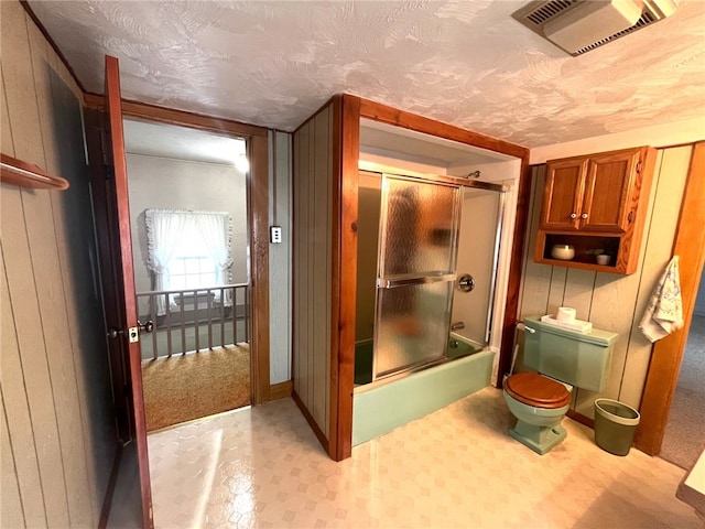 73 Platt St, Hornell, NY 14843 - full bath with enclosed tub / shower combo, a textured ceiling, wooden walls, and tile patterned floors