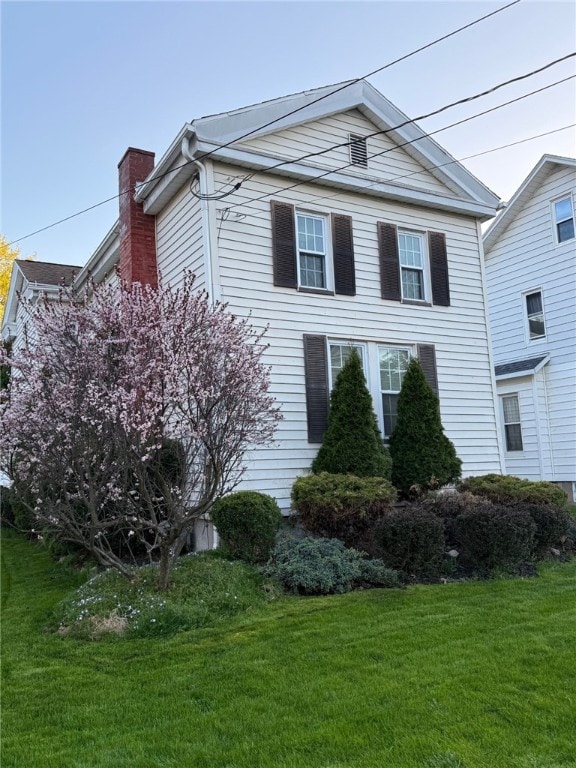 73 Platt St, Hornell, NY 14843 - view of home's exterior featuring a chimney and a yard