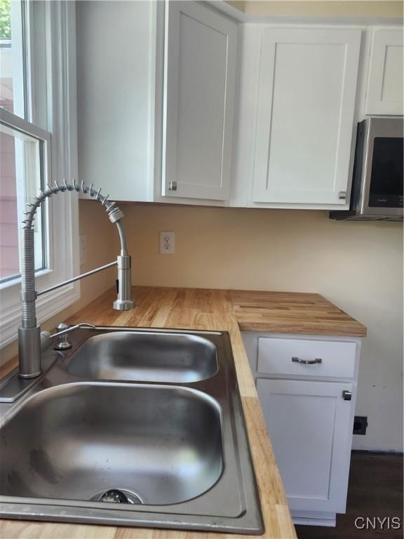 127 Austin Ave, Syracuse, NY 13207 - kitchen featuring stainless steel microwave, butcher block counters, and white cabinetry