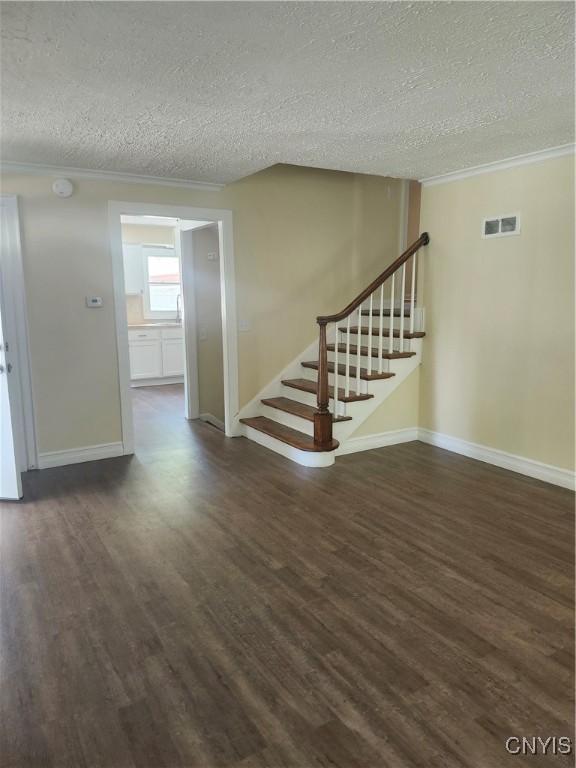 127 Austin Ave, Syracuse, NY 13207 - stairs featuring a textured ceiling, wood finished floors, and ornamental molding