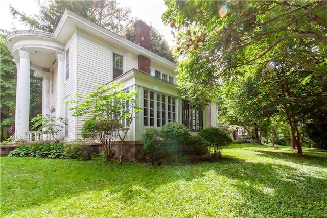 27 E Main St, Sodus, NY 14551 - view of side of home with a chimney and a lawn
