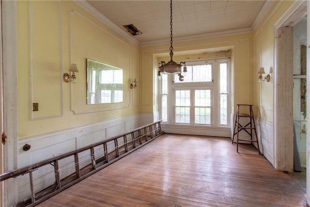 27 E Main St, Sodus, NY 14551 - unfurnished dining area featuring a chandelier, crown molding, wood finished floors, and a decorative wall