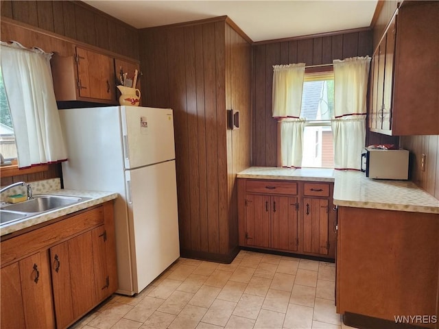 123 Roseland Ave, Ridgeway, NY 14103 - kitchen featuring brown cabinets, light countertops, freestanding refrigerator, and wood walls