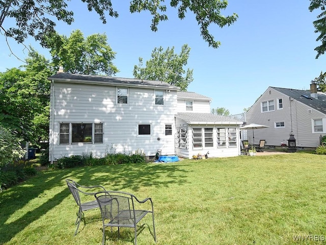 149 Ava Ln, Amherst, NY 14221 - rear view of property featuring a lawn and a sunroom