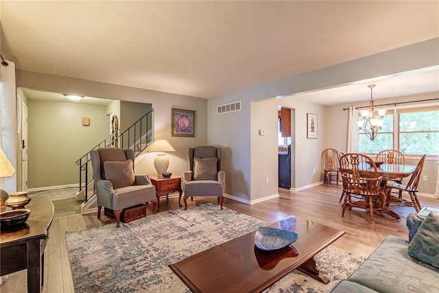 15 Chesapeake Lndg, Henrietta, NY 14586 - living room with light wood-style flooring, stairs, and a chandelier